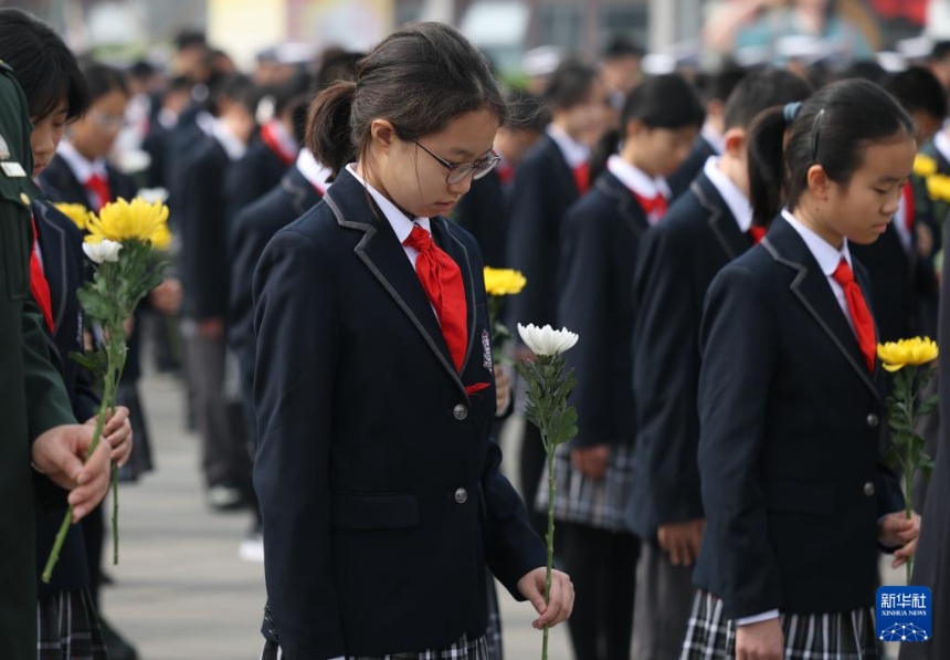 ‘가슴에 새기다’ 주제 교육행사 개막식에서 학생 대표들이 항일 선렬에게 묵념하고 있다. [4월 3일 촬영/사진 출처: 신화사]