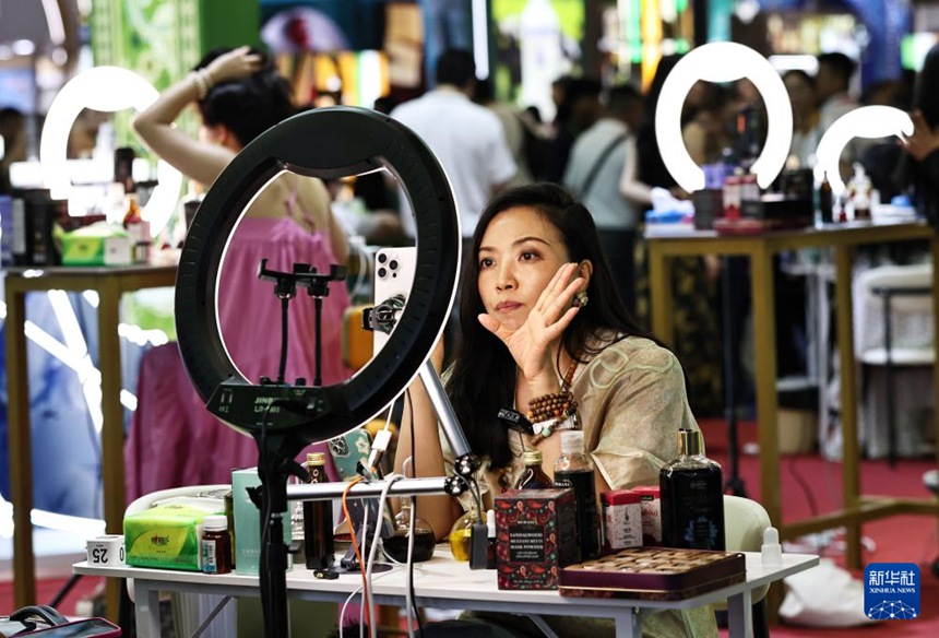 제6회 CICPE의 한 화장품 부스에서 BJ가 라이브 방송을 진행 중이다. [4월 13일 촬영/사진 출처: 신화사]