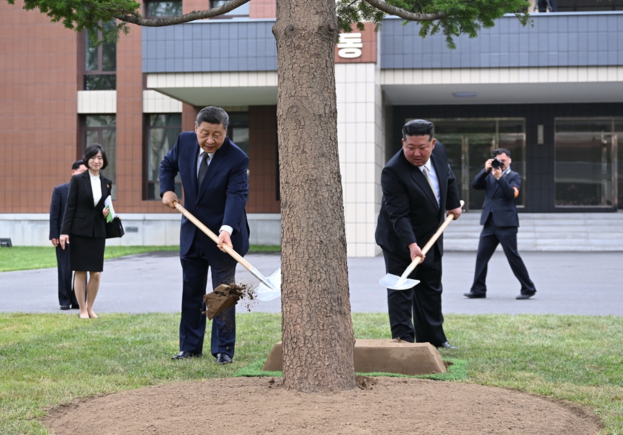 9일 시 주석과 김 위원장이 학교에서 나무를 심는 모습