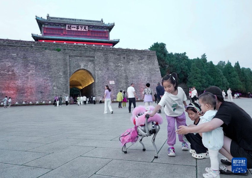 지난 26일, 관광객들이 친황다오시 산하이관구 천하제일관(天下第一關) 관광지에서 로봇견과 교감하고 있다.[사진 출처: 신화사]