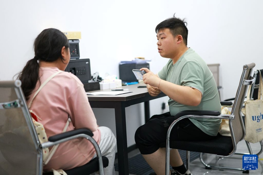 구이양시 윈옌구의 한 데이터 수집 업체에서 데이터 수집원이 한 응답자에게 의료 스마트 웨어러블 설비 데이터 수집 관련 질문을 하고 있다. [7월 6일 촬영/사진 출처: 신화사]