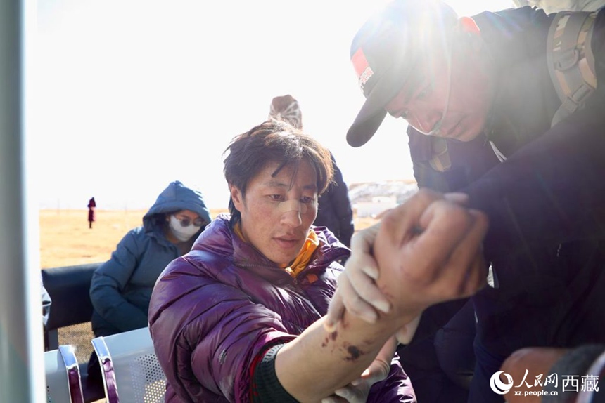 시짱 지원 의료 간부가 바칭현 마루향 대피소에서 이재민의 상처를 검사하고 있다.