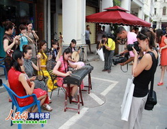 외신 기자들이 하이난의 하이커우(海口)의 치러우라오(骑楼老)거리를 감상하고 있다.