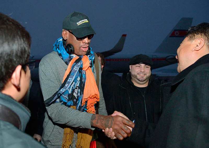 12월 19일, 전 NBA 농구스타 데니스 로드먼(좌측 두 번째)이 평양공항에 도착한 후 마중 나온 관리들과 악수를 하고 있다.