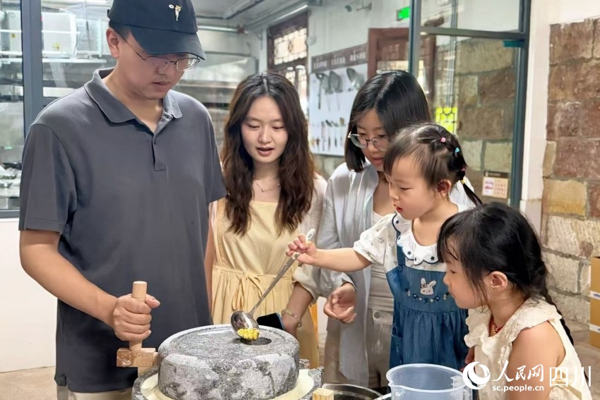 체험 학습 프로그램에 참가한 어린이들이 부모와 함께 간장 제조 일부 과정을 체험하고 있다. [사진 촬영: 양린(楊藺)]