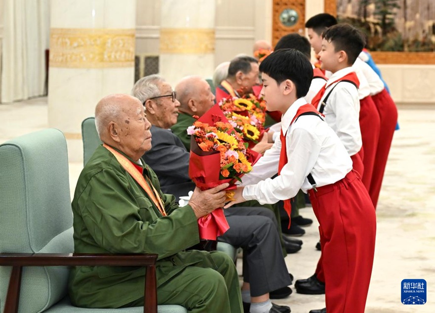 공연 시작 전, 소년선봉대 대원들이 공연을 관람하러 온 항일전쟁 참전 노병 및 원로 동지 대표들에게 꽃을 전달하고 있다. [9월 3일 촬영/사진 출처: 신화사]