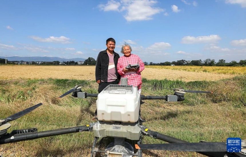 다이수잉 할머니와 손자 왕톈톈이 농업용 드론과 함께 사진을 찍고 있다. [10월 23일 촬영/사진 출처: 신화사]