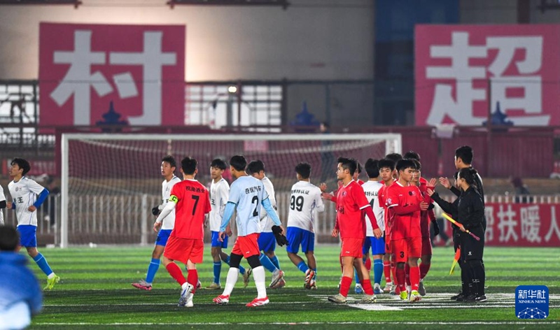 다리(大利) 둥자이(侗寨·둥족 마을) 축구팀 선수들(빨간 유니폼)과 바왕(扒王)촌 축구팀 선수들이 개막전 후 악수를 나누며 인사를 하고 있다. [1월 2일 촬영/사진 출처: 신화사]