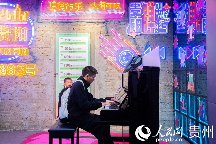 관광객이 칭윈시장에서 피아노를 연주한다.