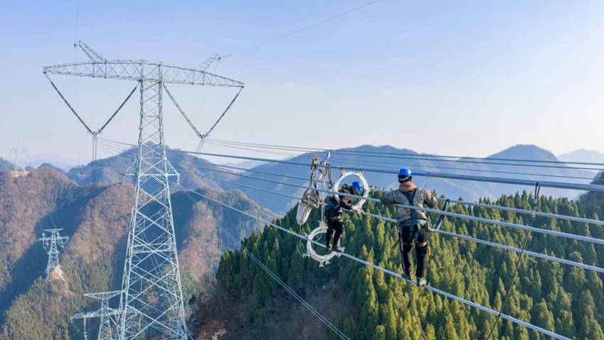 간쑤-저장 ±800kV 특고압 직류 송전 공사 현장에서 작업자들이 철탑에 전선을 연결하는 가선작업을 하고 있다. [사진 촬영: 스쥔(史俊)]