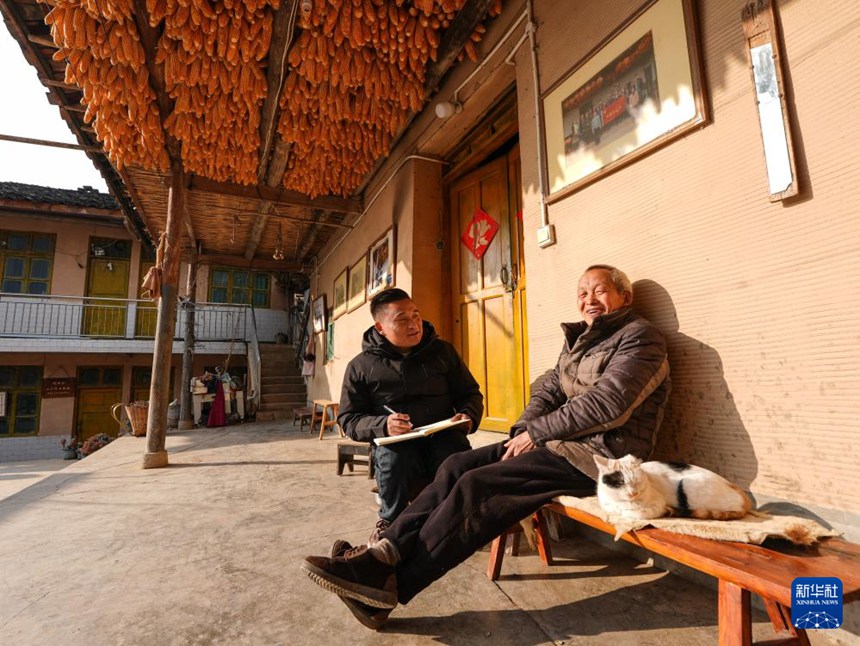 정왕춘 대표가 구루촌 주민 샹카이창(向開強) 씨 댁을 방문해 조사하며 이야기를 나눈다. [1월 28일 촬영/사진 출처: 신화사]