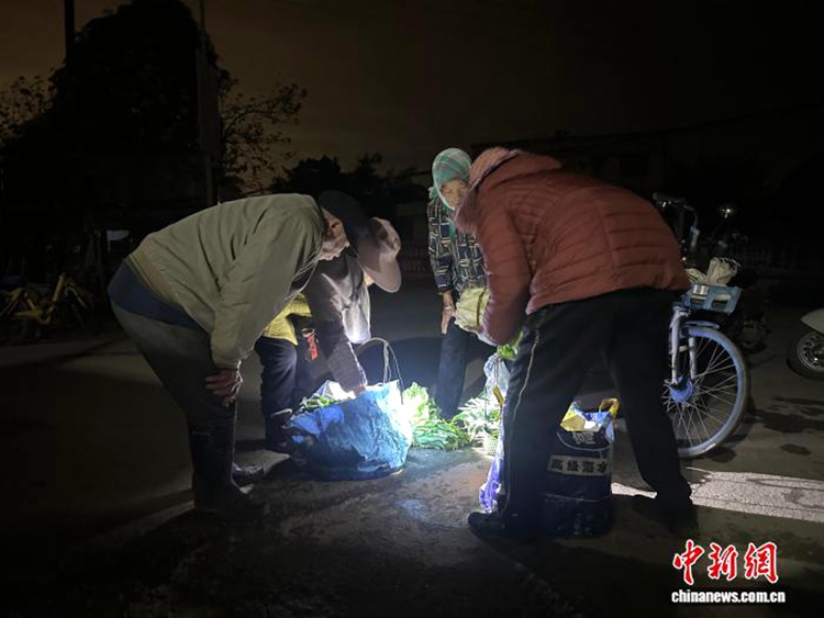주민들이 손전등을 켜고 채소를 고르고 있다. [3월 10일 촬영/사진 촬영: 천옌유]
